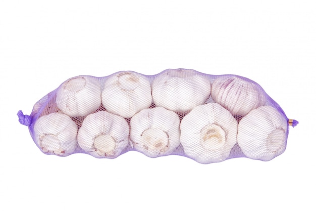 Packed bundle of garlic. On a white wall.