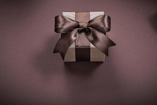 Packed gift box on brown background holidays concept