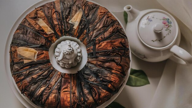 Photo packed pancake of traditional chinese puer tea with white teaput and buddha