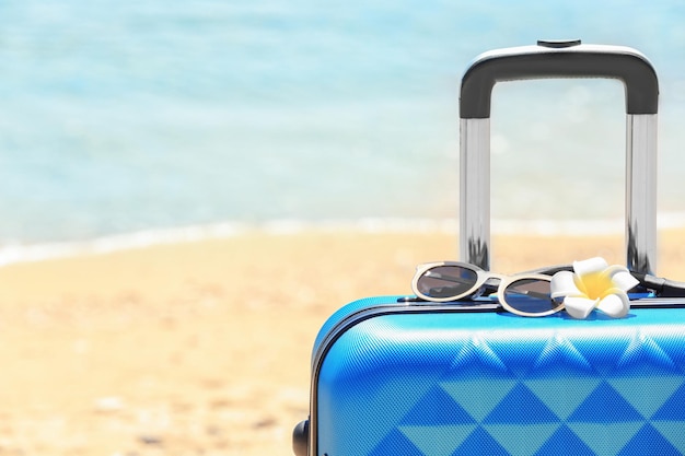 Packed suitcase and sunglasses at sea shore closeup Vacation concept