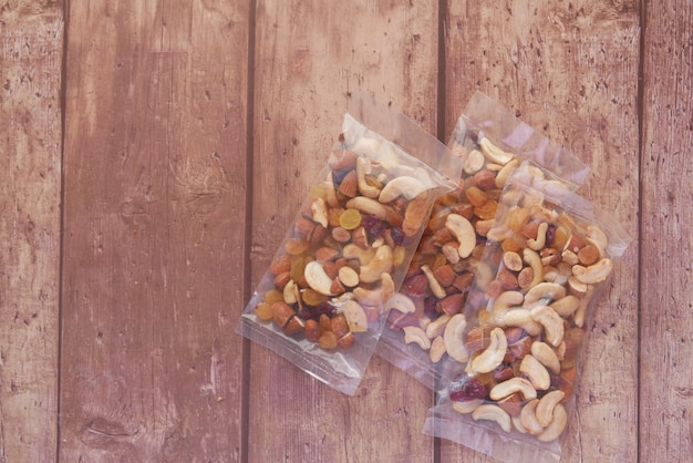 Packet of mixed nuts on wooden background