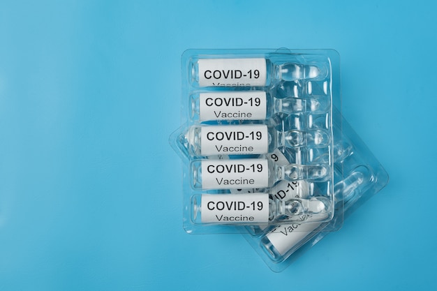 Packing of ampoules with vaccine COVID-19 on blue