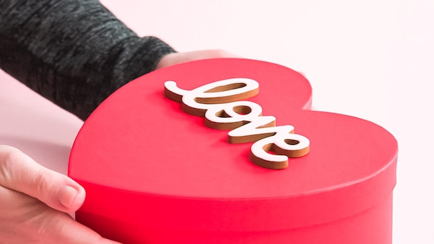 Packing heart shaped sugar cookies decorated with royal icing into the gift box.