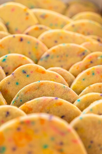 Photo packing sprinkleadorned sugar cookies into boxes