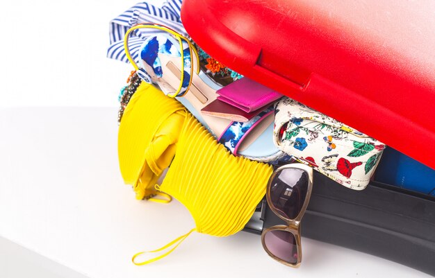 Packing suitcase for trip isolated on white