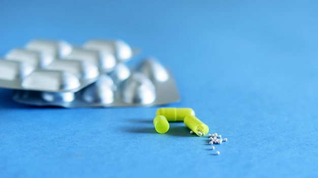 Packs of anti-inflammatory pills on the blue background closeup. The medicine against the virus and diseases.