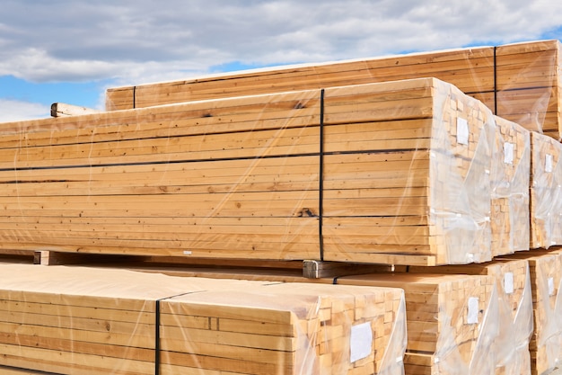 Packs of new wooden planks packed for loading and transportation outdoor