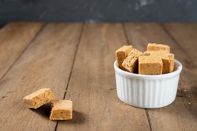 Pacoca is a Brazilian Peanut Sweet on a white bowl on a wooden deks