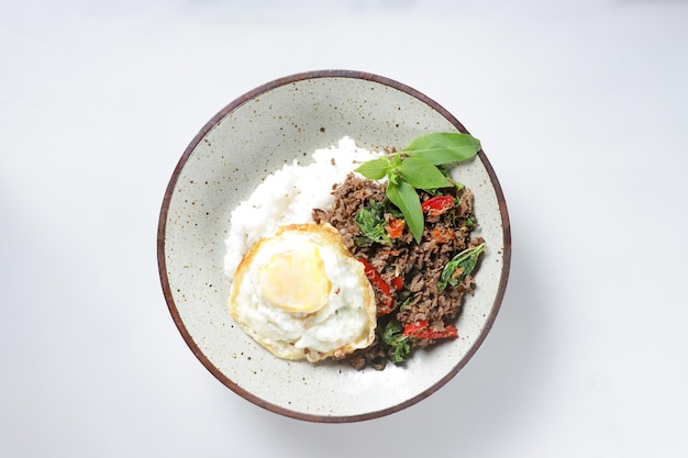 Pad Kra Pao is een Thais roerbakgerecht met heilige basilicum met rundergehakt, geserveerd met gebakken ei en rijst.