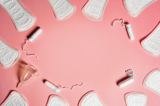 Тампон менструальной чаши подушечки на розовом фоне с копировальным пространством Плоский вид Концепция критических дней менструации Фото высокого качества