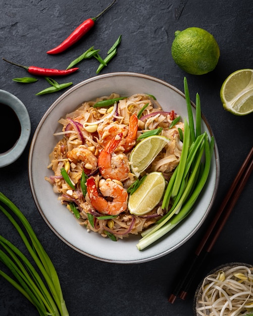 Pad Thai met garnalen op een donkere stenen ondergrond, bovenaanzicht