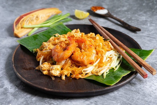 Photo pad thai noodle with shrimps and vegetables close-up on the table.