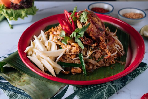 Pad Thai Soft Shell Crab noodle met rode chili in een schotel geïsoleerd op mat bovenaanzicht op grijze marmeren achtergrond