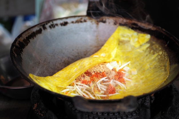 Foto pad thai, un piatto tailandese a base di spaghetti di riso. fried thai egg avvolto in padelle antiche.