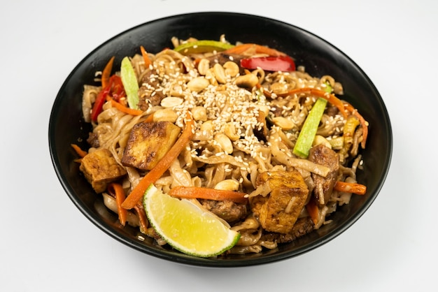 Pad thai vegetarian dish in black dishes on a white background a Thai dish