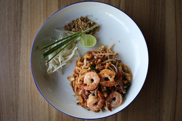 Pad thai with shrimp . Thai food on wood background