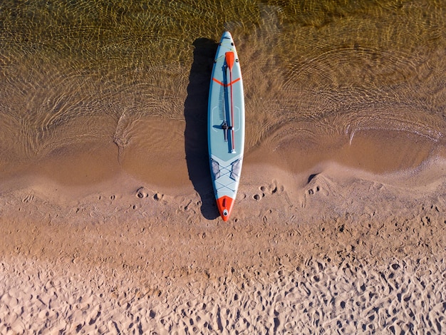 Paddle board op strand met zee achtergrond