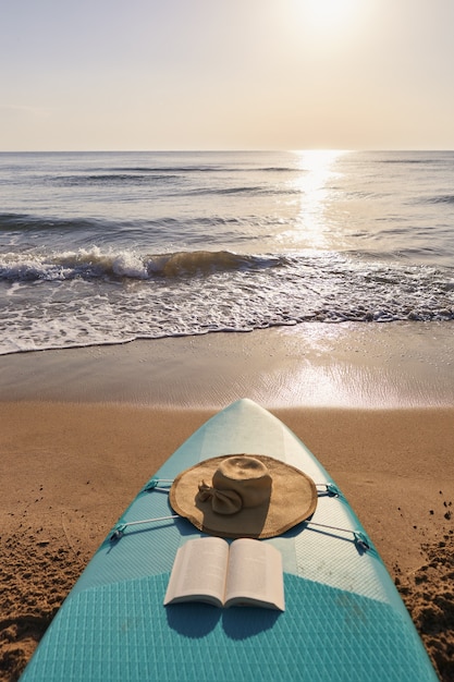 Paddle surf nella sabbia sulla spiaggia all'alba