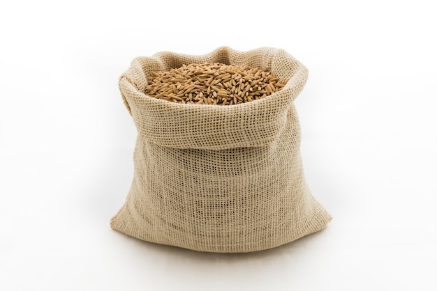 paddy rice in small burlap sack is isolated on white background