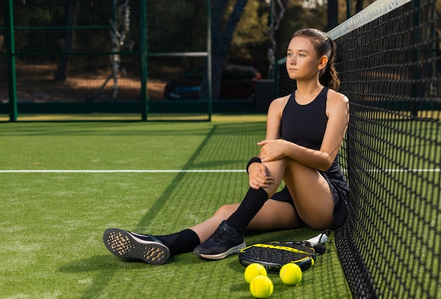 Padel tennis player with racket and ball in hands girl athlete with paddle racket on court outdoors