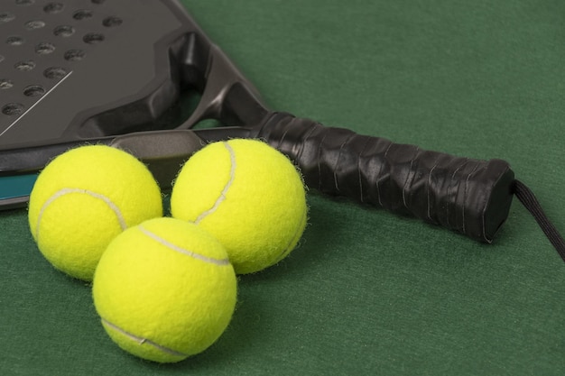 Padel tennisracket en ballen op de groene achtergrond