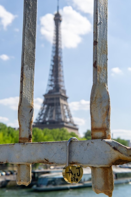 Padlock attached to a bridge with the eiffel tower in the background