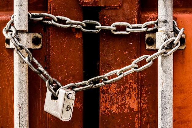 Padlock and chain closing a brown cargo container