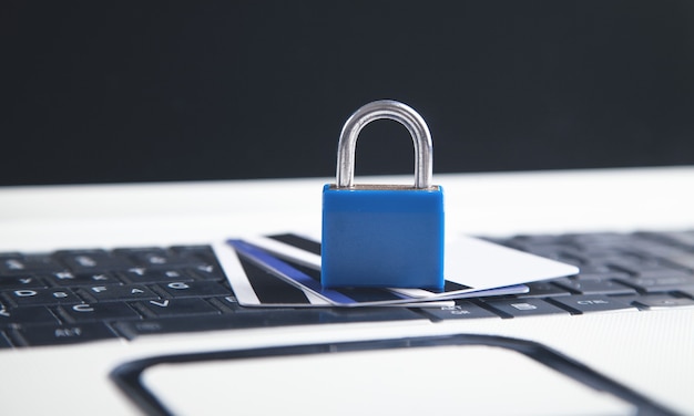 Padlock and credit cards on the computer keyboard. Credit card security