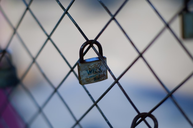 A padlock on a fence with the word " wi " on it