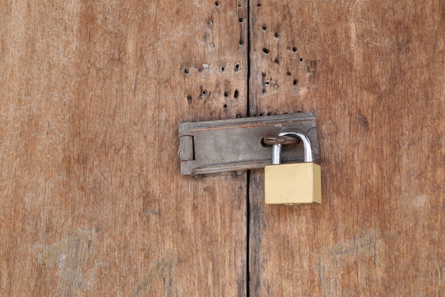 Padlock lock door on old wood door.