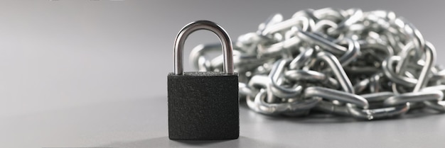 Padlock and metal chains on a gray background