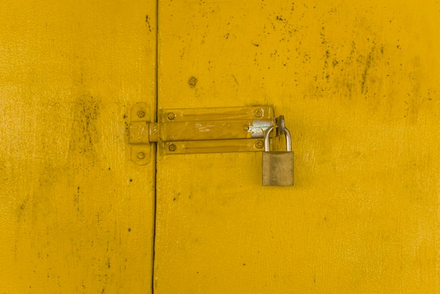 写真 黄色い木製のゲートのパドロックがテクスチャの背景を形成しています