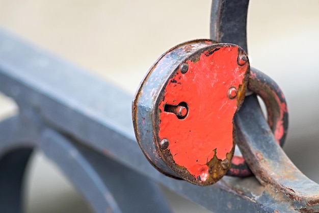 Padlock of red color on an iron fence