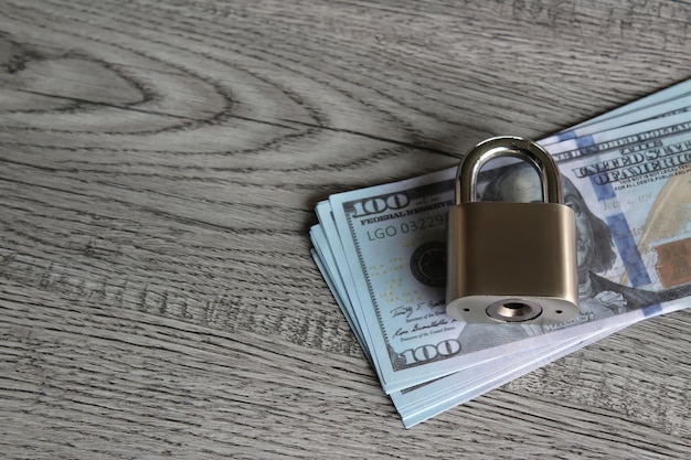 Padlock on top of banknotes copy space for text financial\
protection economic sanctions concept