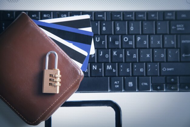 Padlock, wallet and credit cards on the computer keyboard.