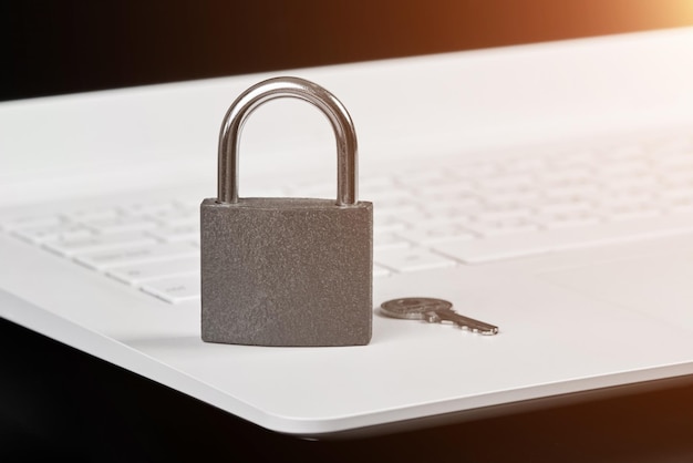 Padlock with a key on a laptop as a concept of protecting information in cyberspace with sunlight