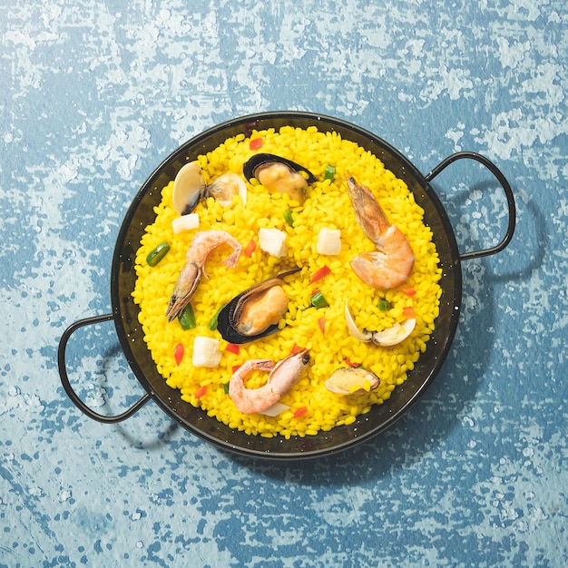 Paella isolated on blue background Top view