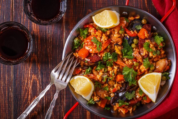 Paella with chicken, chorizo, seafood, vegetables and saffron served in the traditional pan.