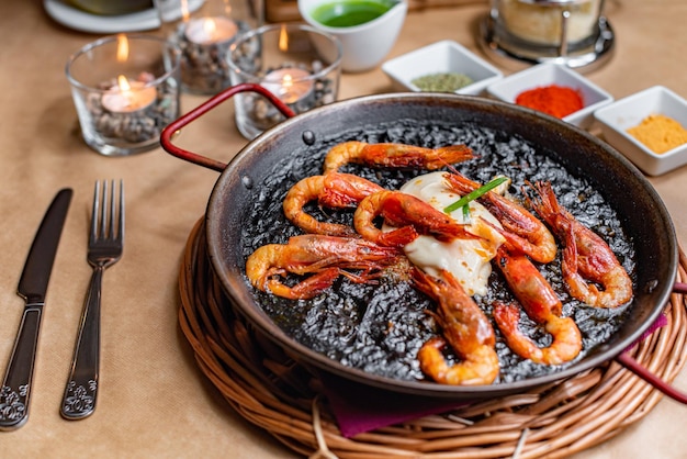 Paella with prawns and black rice