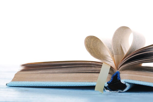 Pages of book curved into heart shape,  on white background