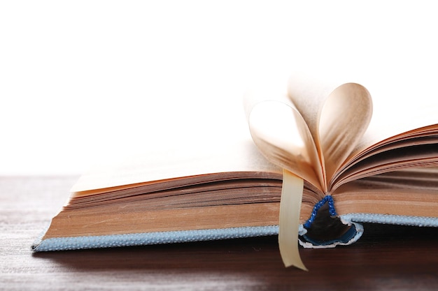 Pages of book curved into heart shape,  on white background