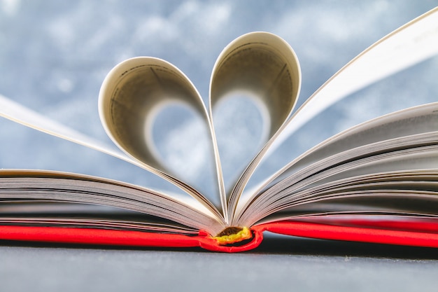 Foto le pagine del libro nella copertina rossa sono fatte sotto forma di un cuore. il concetto di san valentino.