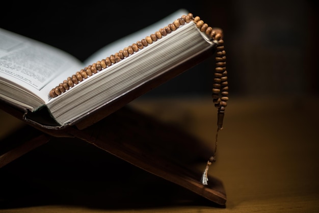 pages of holy koran and rosary at the book