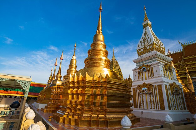 Золотая пагода и церковь в Ват-Тай отражают солнечное небо в дневное время в Бангкоке, Таиланд