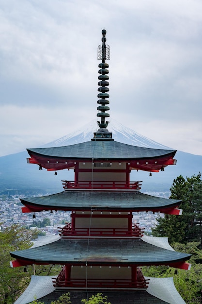 A pagoda with mount fuji behind it