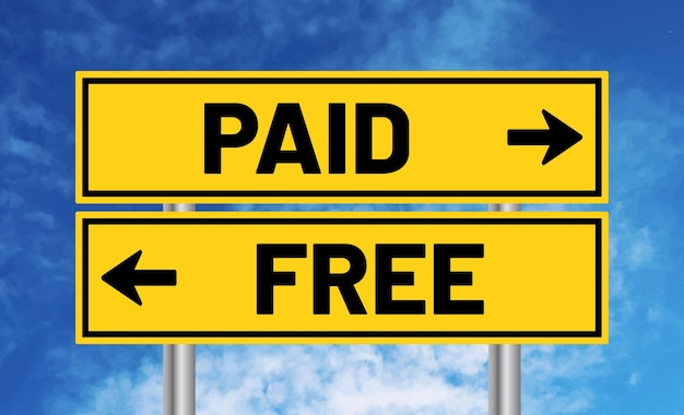 Paid or free road sign on cloudy sky background