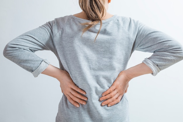 pain in the kidneys. women holding their hands behind their backs. 