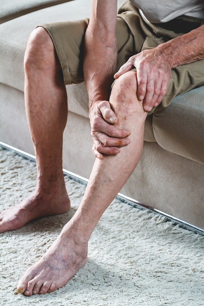 Photo pain in the legs and knees of an elderly senior