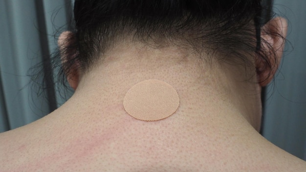 Photo pain relief plaster on man's neck from japan