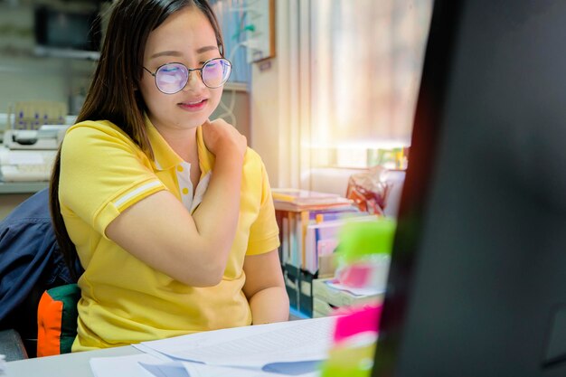 Pain while sitting and working for a long time Shoulder pain back pain concept she is showing pain in the face She is having problems with sitting position inappropriate chair